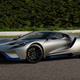 A silver and blue Ford GT sits parked on a race track.